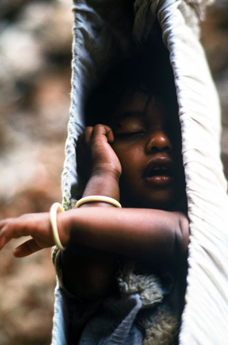 Photo of a child sleeping in a hammock in India by Ron Veto style=
